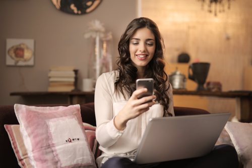 A woman looking at her phone while working from home