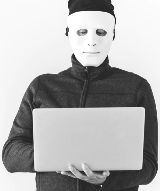 Man in a mask holding a laptop computer