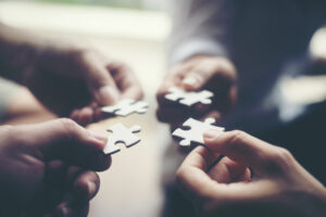 Four people putting the pieces of a jigsaw together